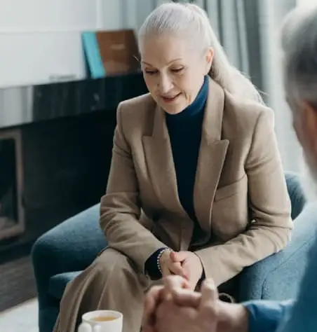 Woman in a beige blazer listening intently.