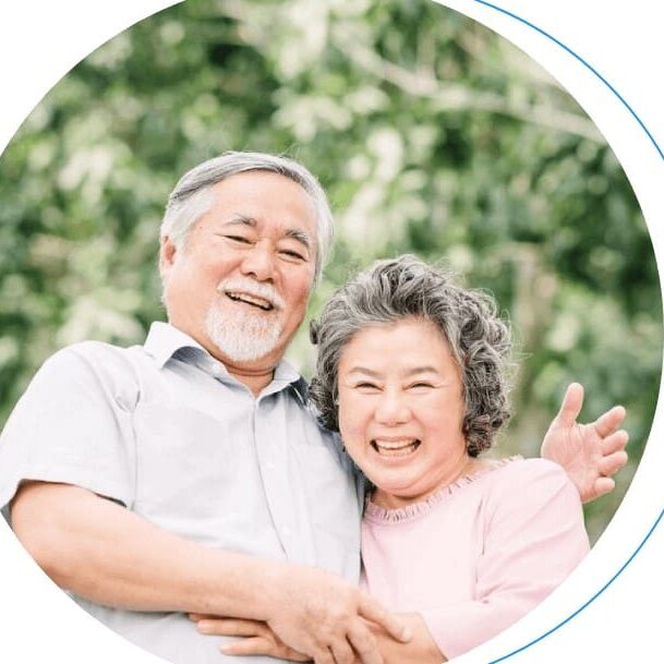 Smiling older couple embracing outdoors.