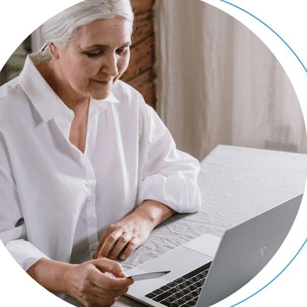 Older woman using a laptop and card.